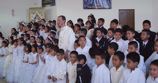 Vision 2016 Herman 2 Starting the week off righ tHerman takes time for a “photo op” with kids at their First Communion.