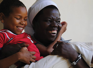 Vision 2017 Tomshack 4 Ugandan sister mends lives Nyirumbe holds a child