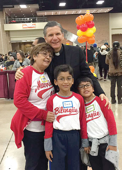 Vision 2021 Gustavo 4 Sólo llámenme Arzobispo Gustavo García-Siller posa con participantes de una gran Cena de Acción de Gracias que se celebra cada año en un centro de convenciones de San Antonio, Texas.