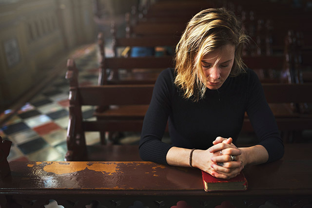 Vision 2022 Scheiber 1 Define your terms Young woman praying while kneeling in a church