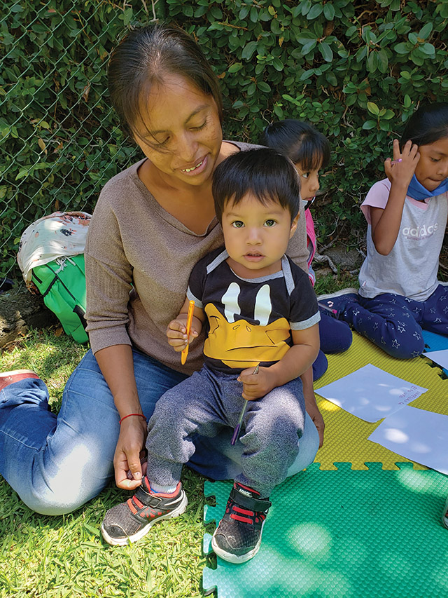 Vision 2022 Long 5 Sister Maggie has a mission Antonia Lopez sits with her son as her daughters behind her work on book reports.
