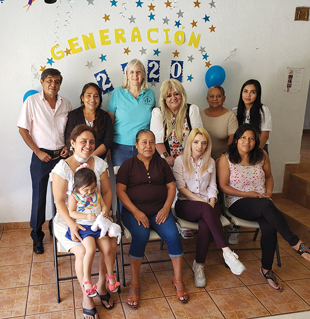 Vision 2022 Long 8 Sister Maggie has a mission Sr. Slowick with volunteers who are also Franciscan Associates. The decorations behind them are from a party celebrating the graduations of children involved in tutoring.