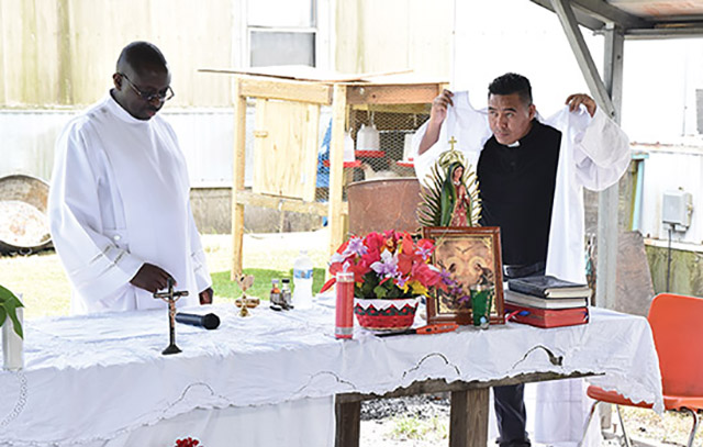 Vision 2023 Feister 7 Ministering to migrants in a carport cathedral Glenmary Fathers Richard Toboso and José Carlos Miguel López vest for Mass among chicken coops and mobile homes.