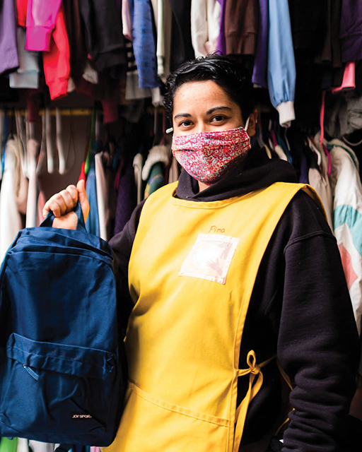 Vision 2024 Feister 4 Mercy meets at the border Sister Josefina “Pina” Bejarano Padilla, M.E., of Kino Border Initiative, holds a backpack in front of racks of donated clothing that will be given to migrants.