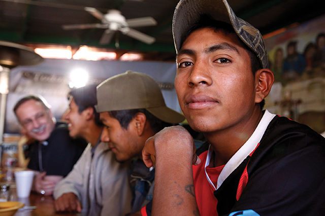 Vision 2024 Feister 6 Mercy meets at the border Across the border in Nogales, Sonora, Mexico, Kino Border Initiative operates an aid center for deported migrants. Here a group of young men awaits dinner while chatting with members of a visiting delegation of U.S. bishops.