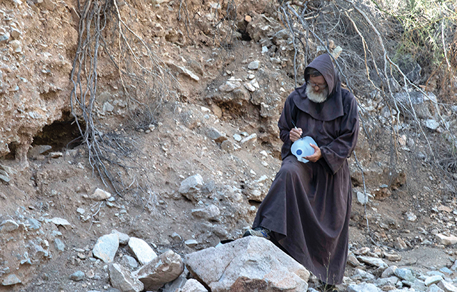 Vision 2024 Feister 9 Mercy meets at the border Franciscan Brother David Buer, O.F.M., writes a hopeful message on a water jug. He travels into the desert from his community in Elfrida, Arizona to leave life-saving jugs of water along migrant pathways.